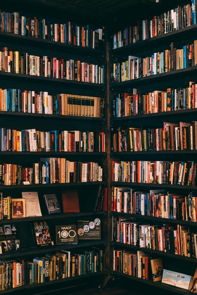 pexels-photo-1907785-1907785 Corner view of a library with dark wooden bookshelves filled with a variety of books.