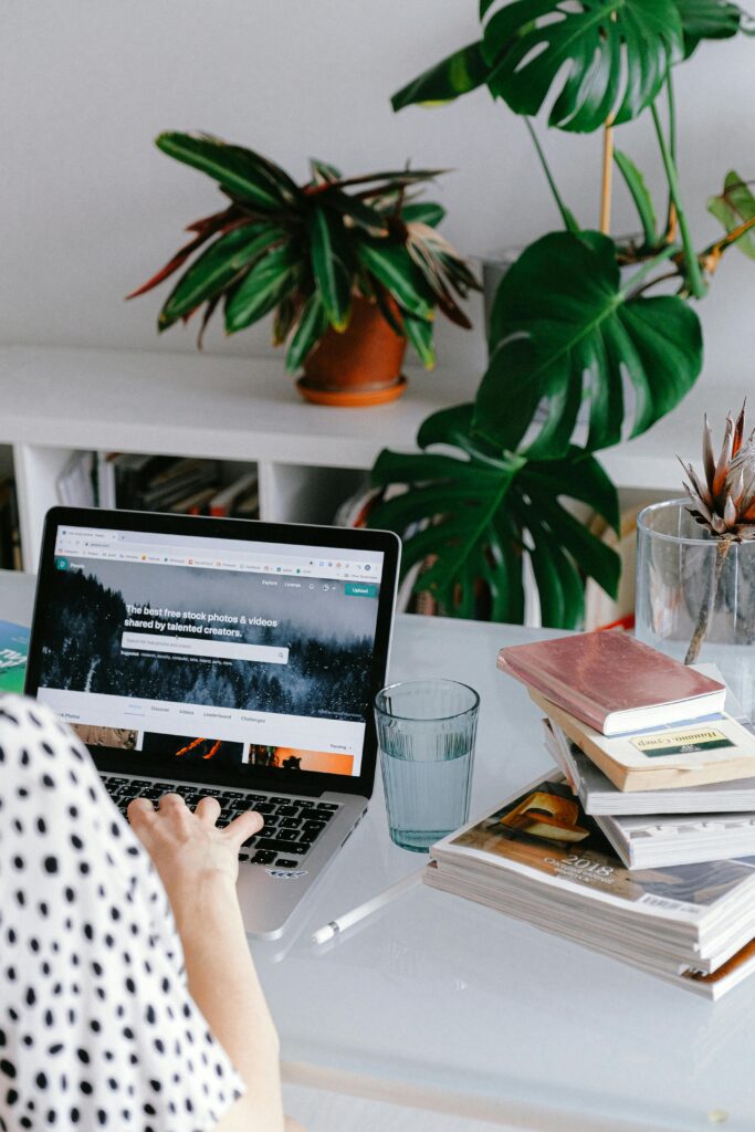 pexels-photo-3987020-3987020 A woman working from home on her laptop surrounded by plants and books for a cozy office feel.